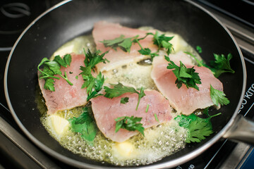 fish fillets cooking with butter in pan