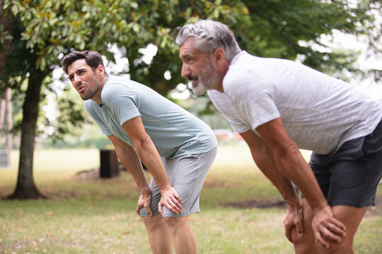 two male athletes rest after running