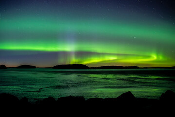 Northern lights dancing over frozen lake in Farnebofjarden national park in north of Sweden. - 755489859