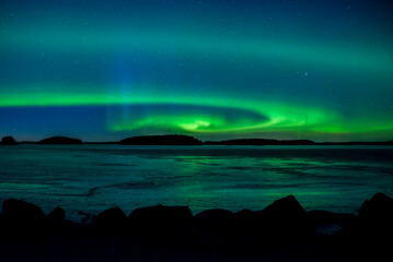 Northern lights dancing over frozen lake in Farnebofjarden national park in north of Sweden. - 755489863