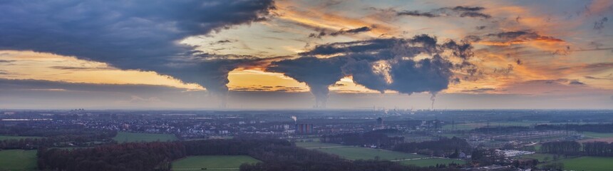 Drone image of the evening sky of the German industrial region of the Ruhr with several chimneys...
