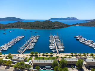 Top view of many luxury boats and yachts in the harbor. Mediterranean, Kas, Antalya - Turkiye. In the background you can see charming holidays in Kalkan, Kas, the islands and the mountains.