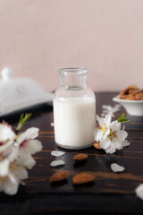 Almond milk with almonds and almond blossoms on the table: the vegan alternative to traditional milk