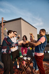 group of joyous multicultural friends drinking tequila with fresh lime and salt at rooftop party