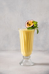 Passion Fruit and mango lassi in traditional tall glass on white background. Healthy beverage made...