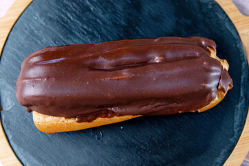 French ecler with chocolate. Traditional french dessert eclair.