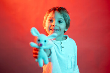 Artistic portrait of a child, boy, lightened with gel filters, studio shot