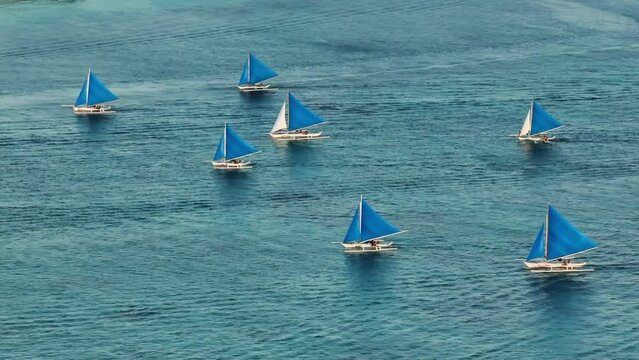 Top view of paraw sailing boats running over the turquoise water. Boracay, Philippines.