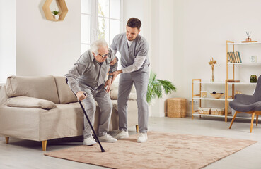 Caring doctor or nurse providing assistance to a senior man at home, offering support and guidance...