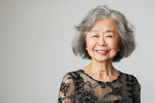 Portrait of old healthy, cheerful beautiful senior Asian woman smiling and looking at camera with white background. Happy aging society, retirement and senior healthcare concept