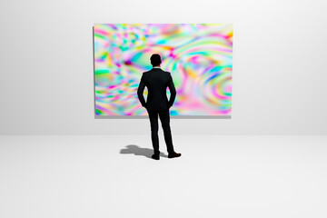 A man in an exhibition hall examines a painting hanging on the wall.