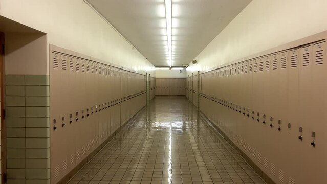 Long school hallway with lockers, worn linoleum tiles, and eerie silence.