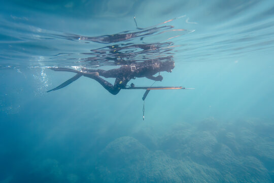 Crop view of scuba diver adult man on a seashore with spearfishing