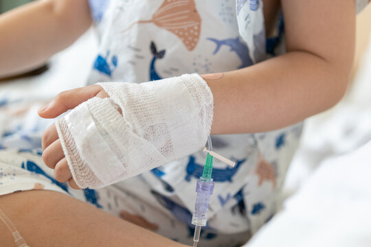 Close up child hand with saline IV solution in hospital