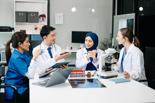  Doctor Talks With Professional Head Nurse or Surgeon, They Use Digital tablet Computer. Diverse Team of Health Care Specialists Discussing Test Result on desk .