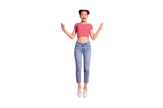 Full length body size photo beautiful she her lady pomade lips cheerleader jump high ecstatic reaction goal fan wear casual jeans denim striped red white t-shirt sit floor isolated pink background