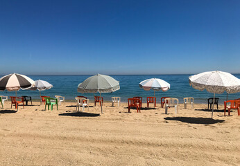 beach umbrellas and chairs in sunny blue sky day
