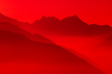 Spectacular mountain ranges silhouettes in shades of red.