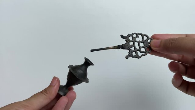 Asian female hand holding an old make up tool used as eye liner. Kohl eyeliner, an ancient metal package, which contain black powder