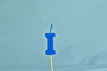 close up on a blue letter I birthday candle on a white background.
