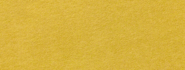 Texture of yellow color felt fabric background, macro. Textile material golden backdrop