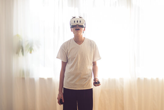 Smiling, white, teenage boy playing VR set Oculus Meta Quest 3. Copy space.	