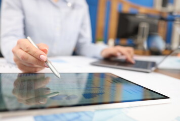 Fototapeta premium Female hand studying information on digital tablet with stylus closeup. Management concept