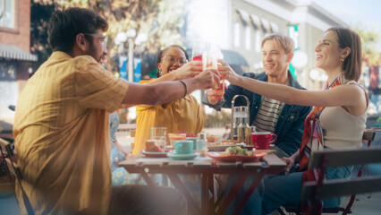 Multiethnic Diverse Friends Gathering Together at a Cafe Terrace Table. Diverse Young People Raising, Toasting and Clinking Glasses with Fresh Juices and Lemonades, Celebrating Their Reunion