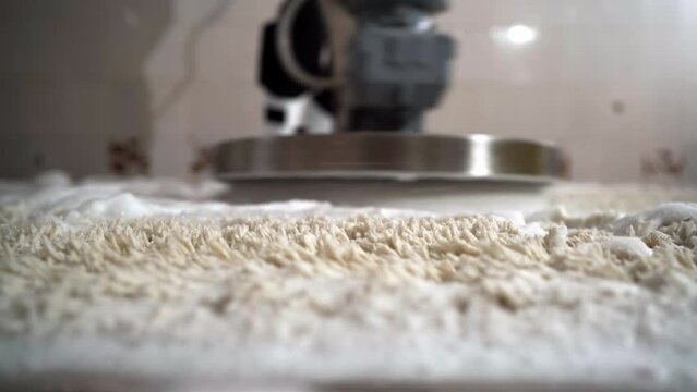 Professional carpet cleaning. Man on carpet cleaning with electric scrubber and foam