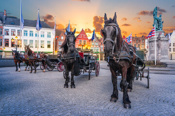Naklejka na ściany i meble Bruges carriage horses on Market Square at dusk, Belgium.