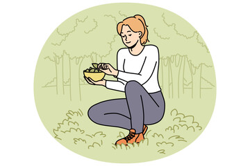 Woman collecting leaves in forest. Happy female gathering plants in wood, putting leaf in basket. Vector illustration.  - obrazy, fototapety, plakaty
