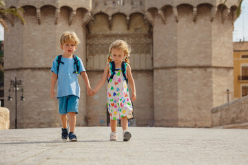 Two siblings walk in front of famous Torres de Serrans - 755574436