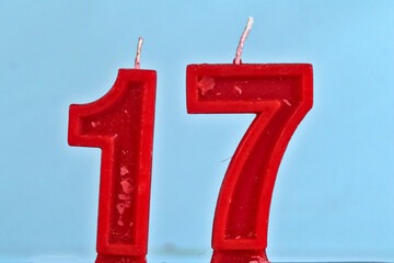 close up on red number seventeenth birthday candle on a white background.
