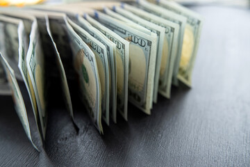 american hundred dollar bills banknotes lies on black desk