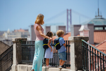 Kids with backpacks and their mother sightseeing in Lisbon - 755576088