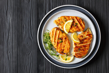 juicy grilled chicken cutlets on plate, top view