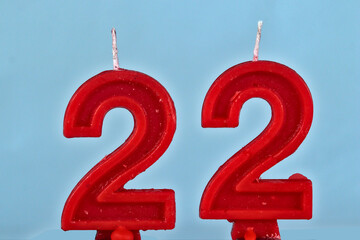 close up on red number twenty two birthday candle on a white background.
