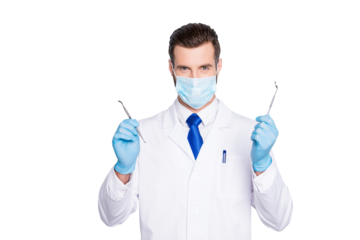 Portrait of successful handsome dentist in white lab coat with blue tie having, showing, holding tools for teeth treatment with hands, looking at camera, isolated on grey background