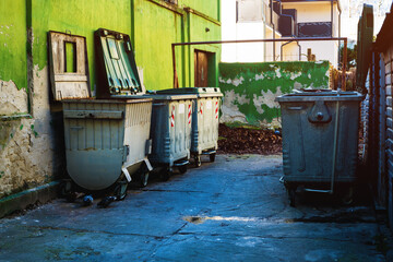 Trash container dumpsters in dirty alley