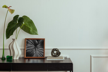 Elegant composition of living room interior with mock up poster frame, black desk, rattan armchair,...