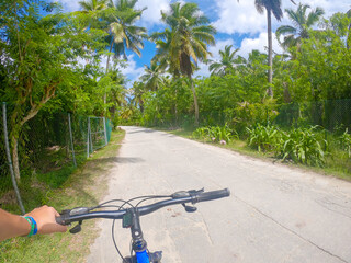 Lonely cyclist traveling through La Digue island jungle in Seychelles - 755583255