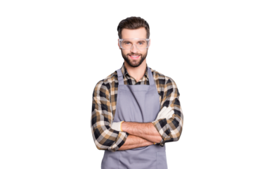 Portrait of attractive joyful carpenter with hairstyle in safety glasses looking at camera having his arms crossed standing over grey background