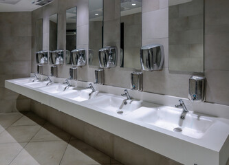 Washbasins with mirrors and soap dispensers in public toilet at truck stops on Italian highway