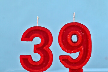 close up on red number thirty ninth birthday candle on a white background.
