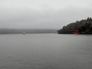 雪の降る芦ノ湖と鳥居。