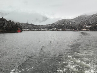 雪の降る芦ノ湖を船から。