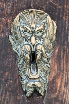 Ornate Antique Door Knocker on Weathered Wood