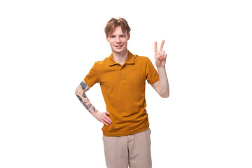 Fototapeta na wymiar young red-haired caucasian student man with a tattoo dressed in a mustard t-shirt gesturing