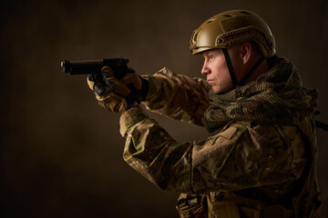 Fototapeta premium portrait of an airsoft soldier in camouflage clothing with an airsoft gun