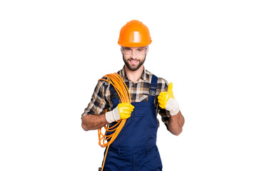 Portrait of handsome joyful electrician in hardhat, overall, shirt with bristle, holding rolled...